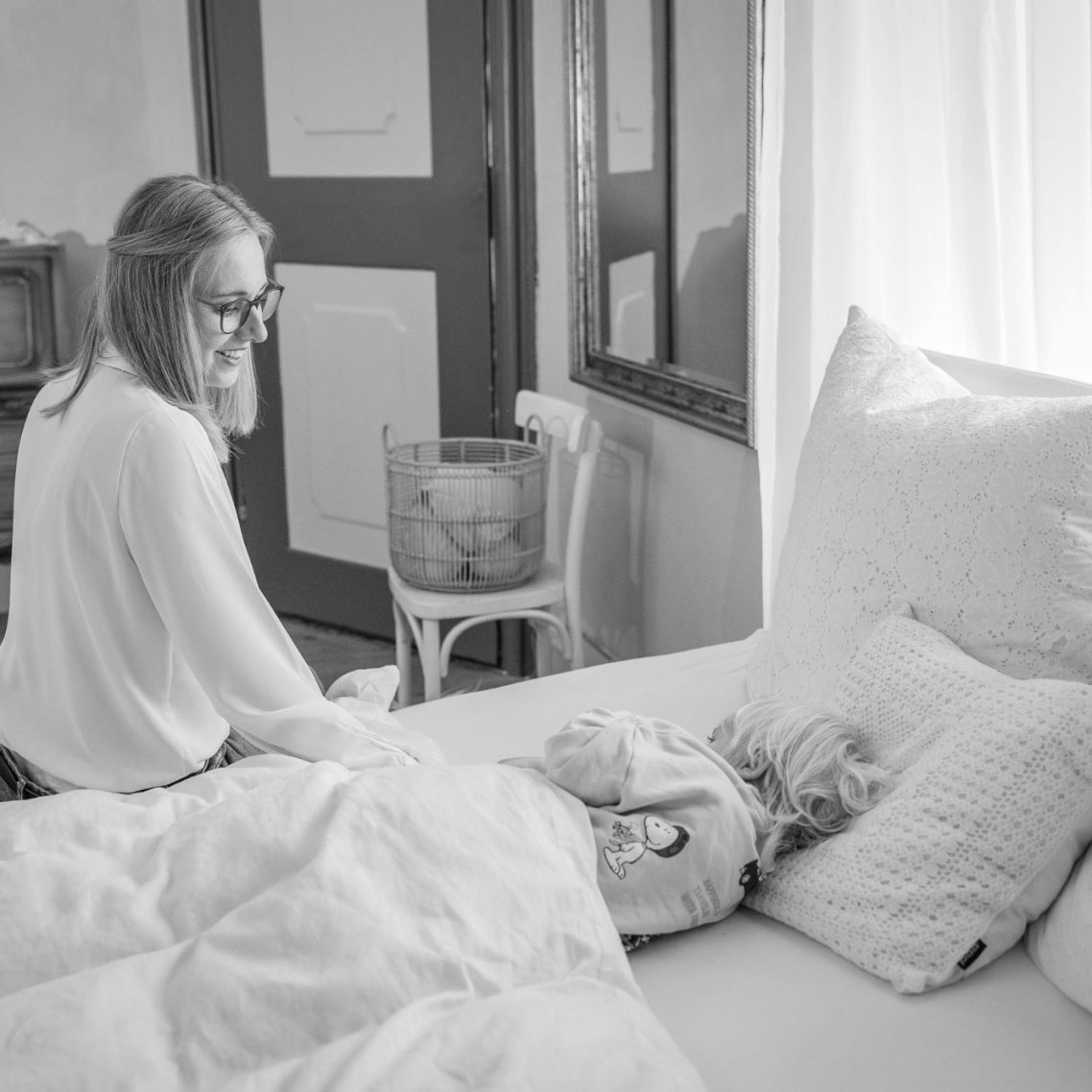 Schlafendes Baby in den Armen einer Person, sanfte und beruhigende Atmosphäre.